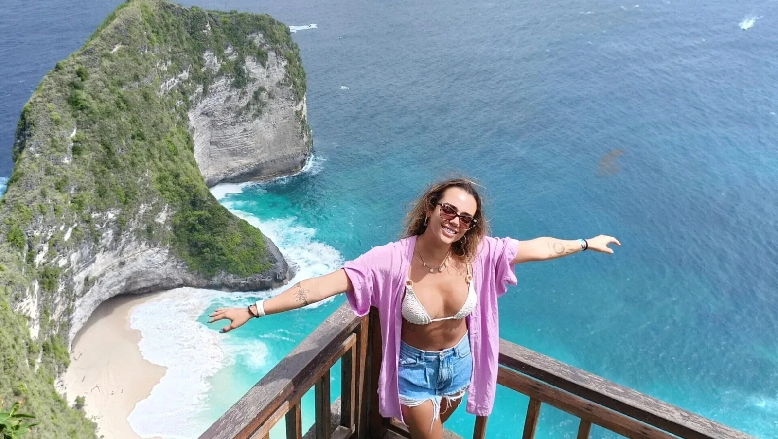 A traveler at the Kelingking Beach cliff viewpoint in Nusa Penida.